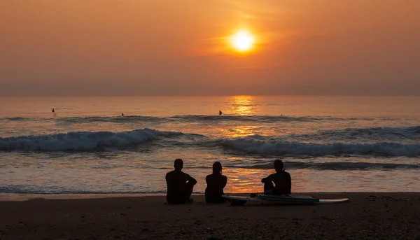 Surfistas admirando el atardecer —  Fotos de Stock