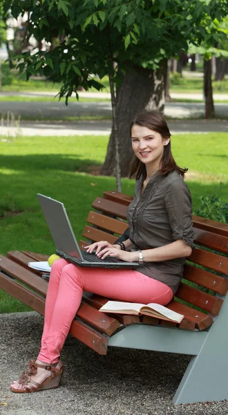 Junge Frau mit Laptop in einem Park — Stockfoto