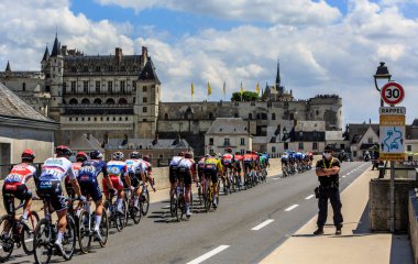 Amboise, Fransa - Temmuz 12021: Fransa Bisiklet Turu sırasında Amboise Kalesi 'nin önündeki köprüden geçen pelotonun arka görüntüsü.