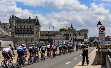 Amboise, Fransa - Temmuz 12021: Fransa Bisiklet Turu sırasında Amboise Kalesi 'nin önündeki köprüden geçen pelotonun arka görüntüsü.
