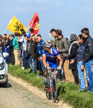 Carrefour de l 'Arbre, Fransa-Nisan 13, 2014: FDJ.fr Takımı' ndan Brezilyalı bisikletçi Murilo Antonio Fischer, 2014 yılında Camphin-en-Pvle kasabasında bulunan ünlü kaldırım taşı sektörü Carrefour de l 'Arbre' ye binerken takımının arabasına bakıyor  
