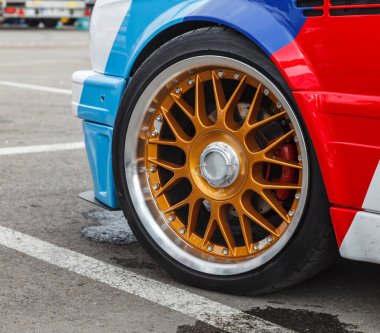 Bir otoparkta sürüklenen bir arabanın kullanılmış tekerleğinin yakın çekimi..