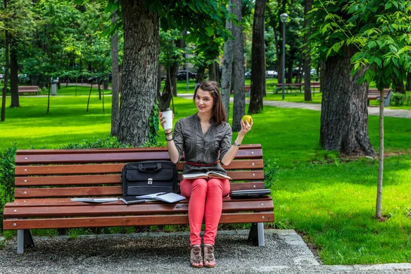 Young Woman Studying Park Holds Green Apple Cup Coffee Looking — Stock fotografie