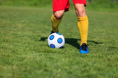 Top süren bir futbolcunun ayaklarının yakın plan görüntüsü.