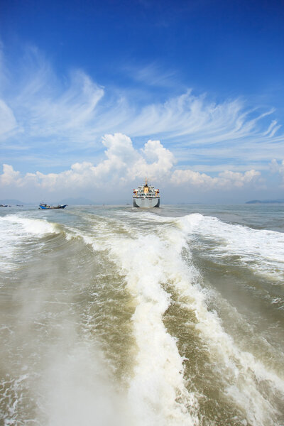 Boat wake and cargo ship