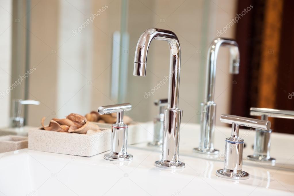 High spout faucet and bowl in front of a mirror