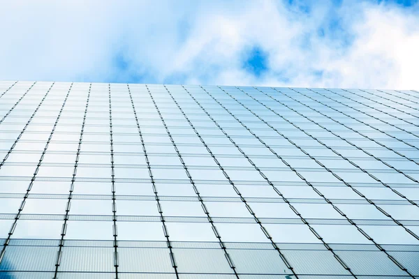 Blauwe hemel en zakelijke wolkenkrabbers met muur gemaakt volledig van glas — Stockfoto