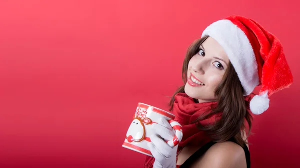 Женщина держит чашку чая на красном фоне — стоковое фото