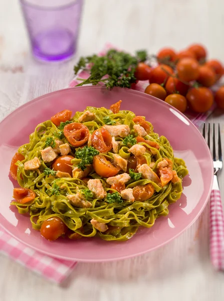 Green tagliatelle with fresh salmon and tomatoes, selective focu — Stock Photo, Image