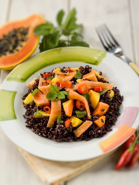 Черный рис с папайей и копченым лососином, избирательный фокус — стоковое фото