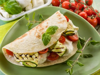 piadina with mozzarella, grelled zucchinis and tomatoes, typica clipart