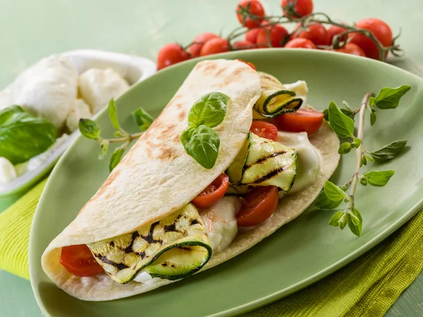 Piadina with mozzarella, grelled zucchinis and tomatoes, typica — Stock Photo, Image