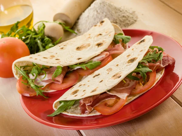 Piadina met ham, rucola en tomaten, typisch Italiaanse sandwich — Stockfoto