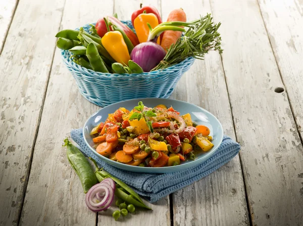 Verduras salteadas mixtas en el plato sobre fondo de madera —  Fotos de Stock