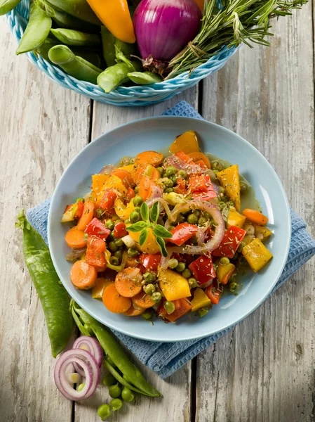 Verduras salteadas mixtas en el plato sobre fondo de madera —  Fotos de Stock