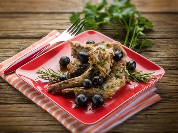 Roasted rabbit with herbs and black olives, selective focus — Stock Photo, Image
