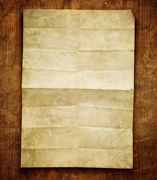 Старый лист бумаги на деревянном столе — стоковое фото