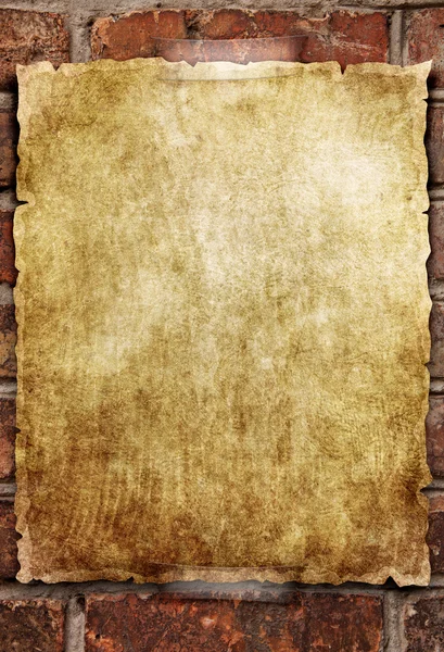 Oude papier blad stok op bakstenen muur — Stockfoto