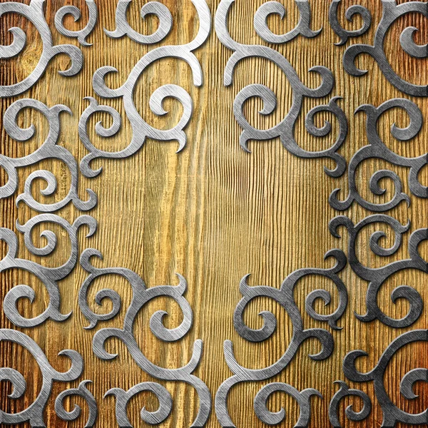 Metal ornament on old wooden background — Stock Photo, Image