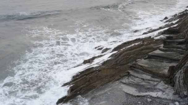 Kleine golven langs de kust van een rots — Stockvideo