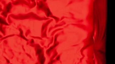 Bright Red Cloth reverse and sliding slowly from Right to Left with a bit of Wind on a Black Background