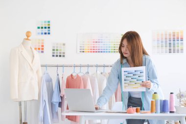 Moda tasarımcısı stüdyoda çalışıyor, çizim kesme, dikiş elbise