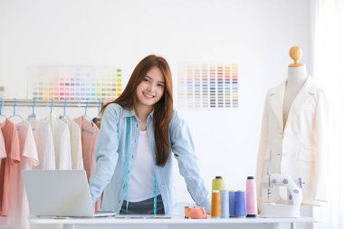 Moda tasarımcısı stüdyoda çalışıyor, çizim kesme, dikiş elbise