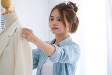 Moda tasarımcısı stüdyoda çalışıyor, çizim kesme, dikiş elbise