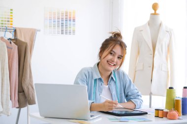 Moda tasarımcısı stüdyoda çalışıyor, çizim kesme, dikiş elbise