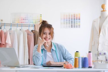 Moda tasarımcısı stüdyoda çalışıyor, çizim kesme, dikiş elbise