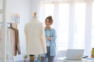 Moda tasarımcısı stüdyoda çalışıyor, çizim kesme, dikiş elbise