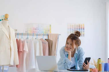 Moda tasarımcısı stüdyoda çalışıyor, çizim kesme, dikiş elbise