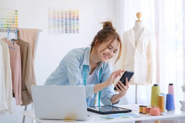 Moda tasarımcısı stüdyoda çalışıyor, çizim kesme, dikiş elbise