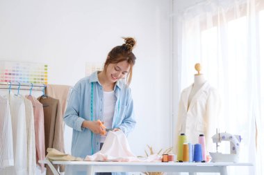 Moda tasarımcısı stüdyoda çalışıyor, çizim kesme, dikiş elbise