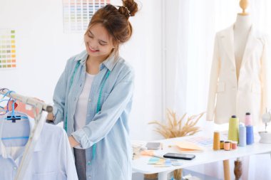 Moda tasarımcısı stüdyoda çalışıyor, çizim kesme, dikiş elbise