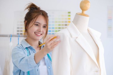 Moda tasarımcısı stüdyoda çalışıyor, çizim kesme, dikiş elbise