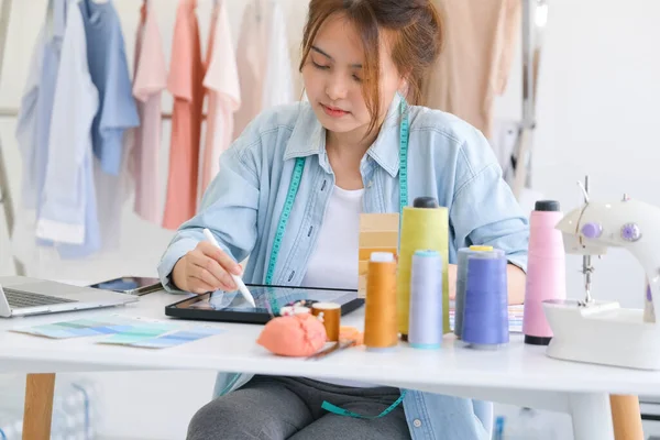 Moda tasarımcısı stüdyoda çalışıyor, çizim kesme, dikiş elbise