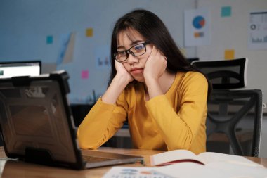 Genç Asyalı bir kadın gece evde çalışıyor ve öğreniyor..