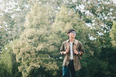 Sırt çantalarıyla yürüyen genç bir adam..