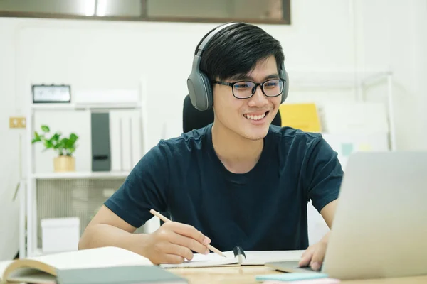 Jongeman studeren in de voorkant van de laptop computer thuis — Stockfoto