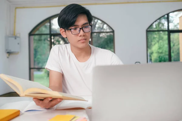 Młody student collage za pomocą komputera i urządzenia mobilnego studiuje online. — Zdjęcie stockowe