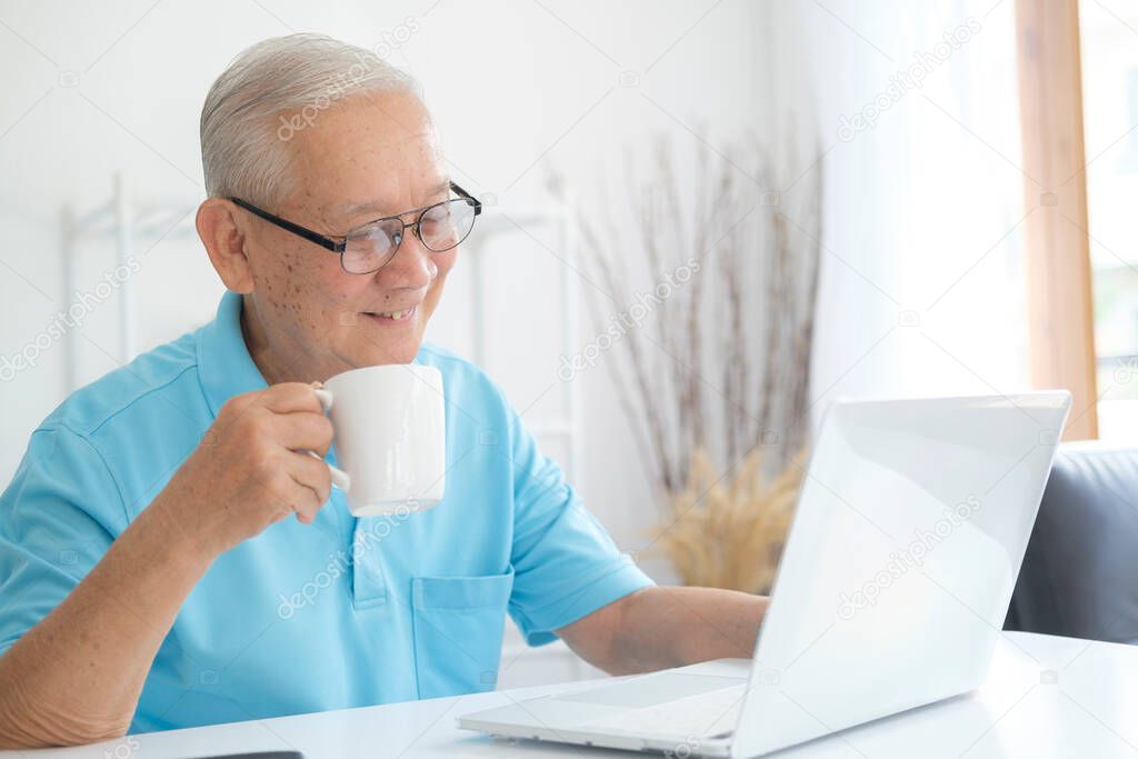 Senior man using laptop for online at home.
