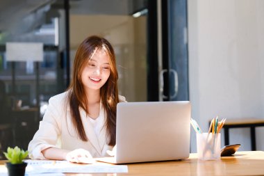 İş kadını ofiste çalışıyor ve bilgisayarını kullanıyor..