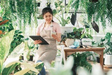 Genç bayan bahçıvan bahçede müşterilerle iletişim kurmak için bekliyor..