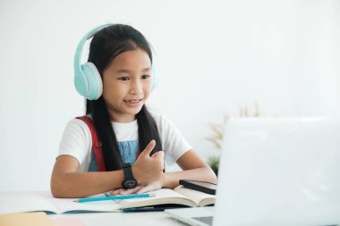 Uzaktan eğitim. Çocuk gülümsemesi, parmaklar yukarı ve evde online çalışma.