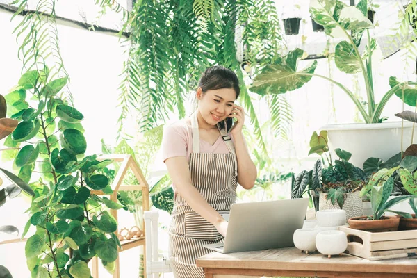 Genç bayan bahçıvan bahçede müşterilerle iletişim kurmak için bekliyor..