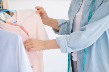Moda tasarımcısı stüdyoda çalışıyor, çizim kesme, dikiş elbise
