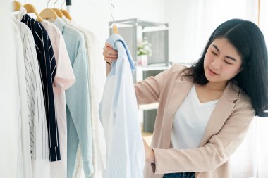 Genç iş adamı, küçük işletmelerdeki kıyafetleri kontrol ediyor. Depodaki envanteri kontrol ediyor. Mağaza teftişi.