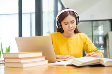 Bilgisayar ve mobil aygıt kullanan genç kolaj öğrencisi çevrimiçi eğitim, çevrimiçi eğitim veya kendi kendine öğrenim kavramı.