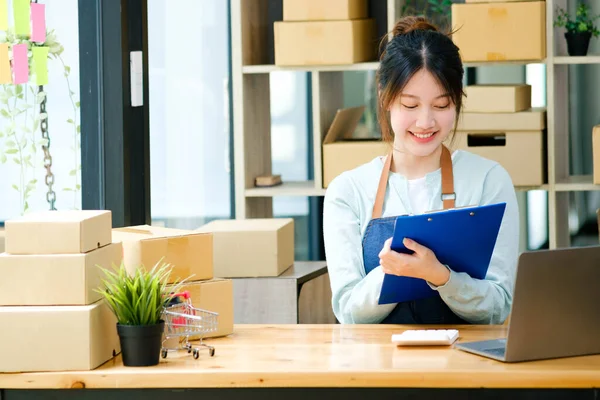 İş kadını, postaneye müşteri göndermeden önce kontrol emri için çalışmaya başlar..